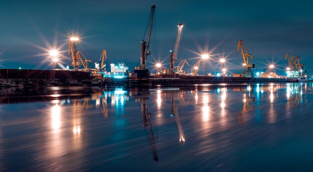 Illuminated pier over sea against sky at night