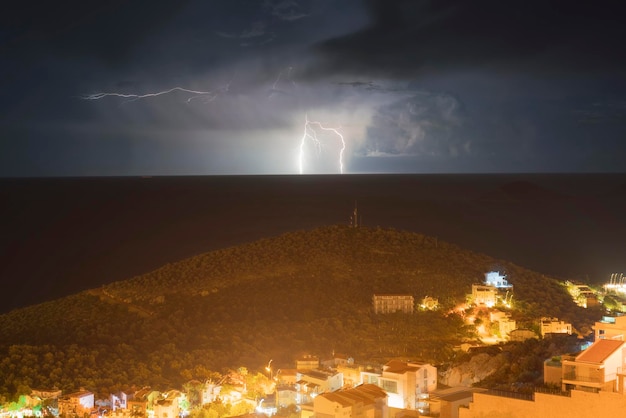 Illuminated resort city at night with lightning in the sky top view