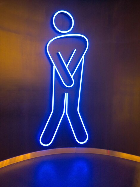 Illuminated restroom sign on wall