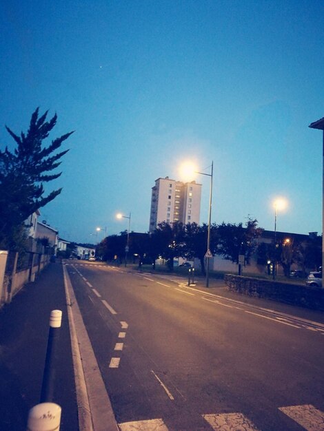 Illuminated road against sky at night