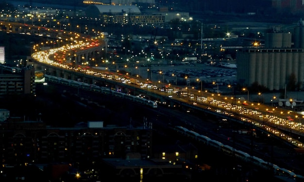 Illuminated road amidst buildings in city at night