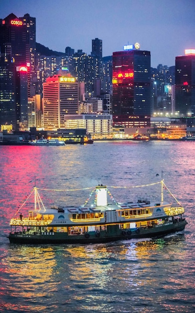 Photo illuminated ship in sea against city