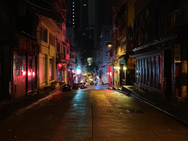 illuminated street amidst buildings in city at night