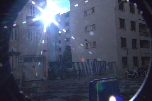 Illuminated street amidst buildings in city at night