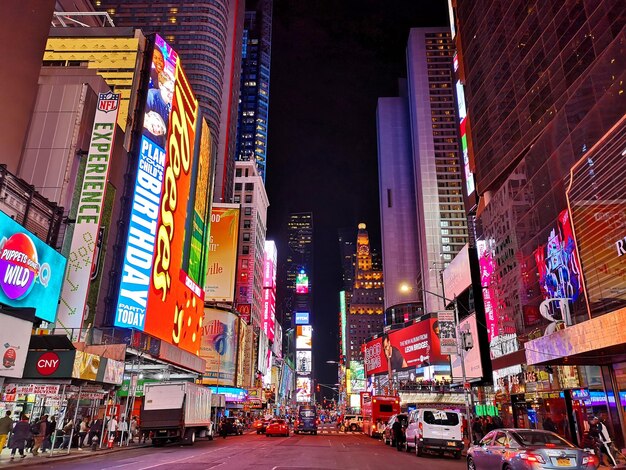 Illuminated street amidst buildings in city at night