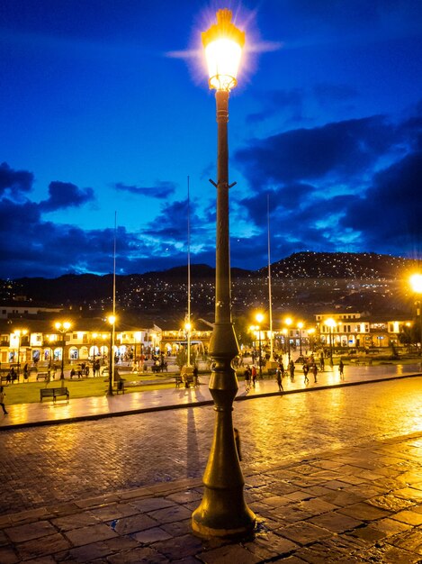 Illuminated street light against sky at night