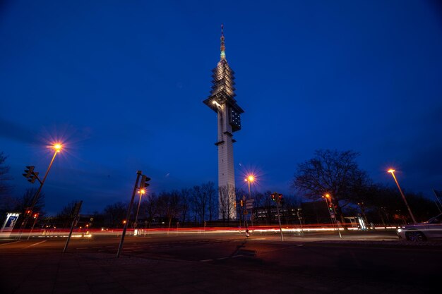 Illuminated street lights against blue sky at night