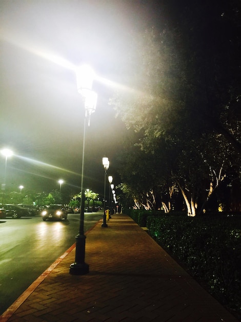 Illuminated street lights on sidewalk at night in irvine spectrum center