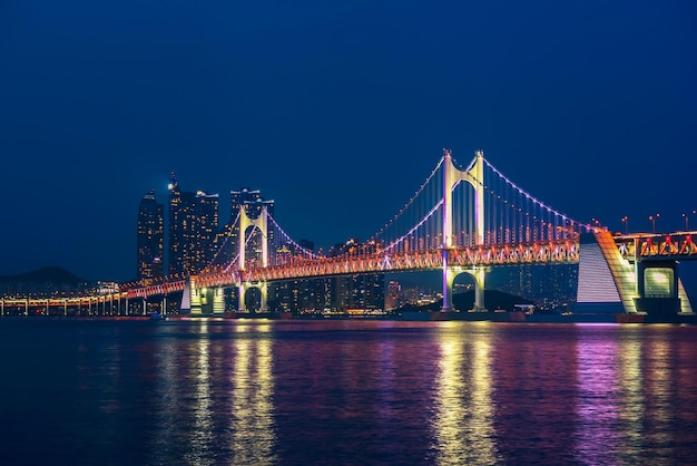 illuminated suspension bridge over river at night