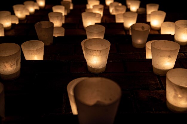 Illuminated tea light candles in darkroom