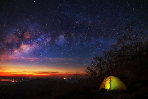 夜晚在星空前面的田野上照亮的帐