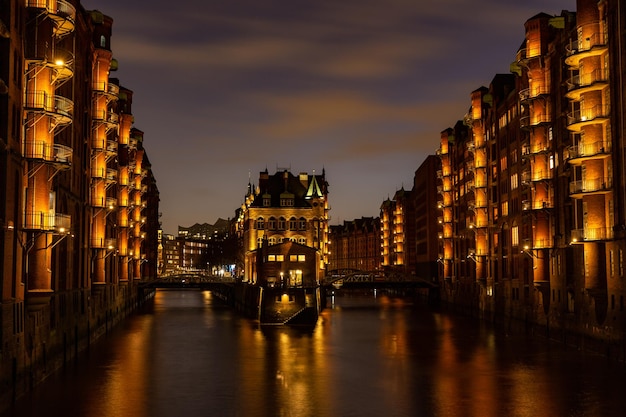 Illuminated wasserschloss speicherstadt hamburg at sunset with lights reflecting in the water