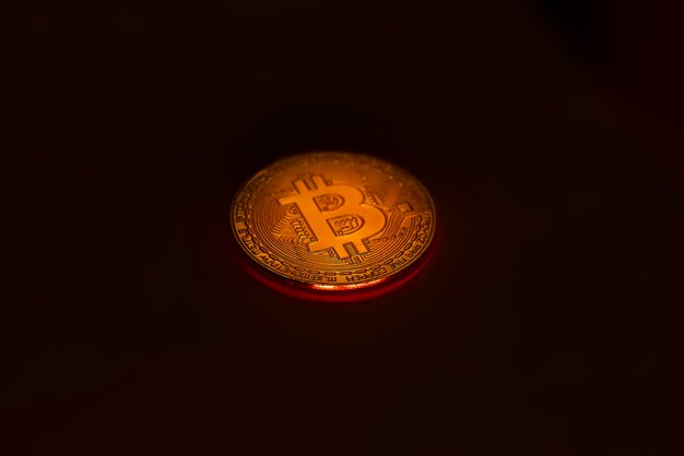 Illuminating Bitcoin coin on black background