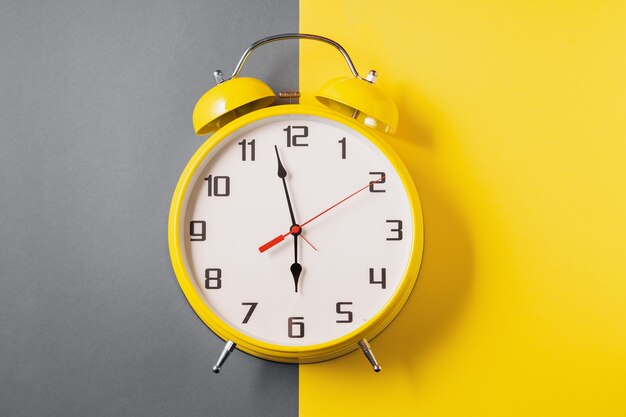 Illuminating color Retro style alarm clock on ultimate gray and yellow