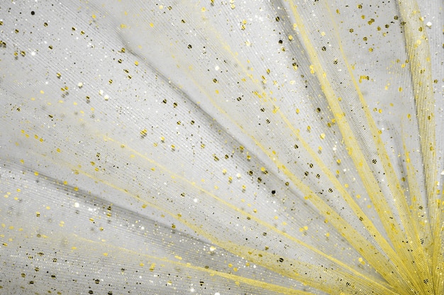 Tessuto drappeggiato giallo illuminante con glitter sulla superficie ultimate grey