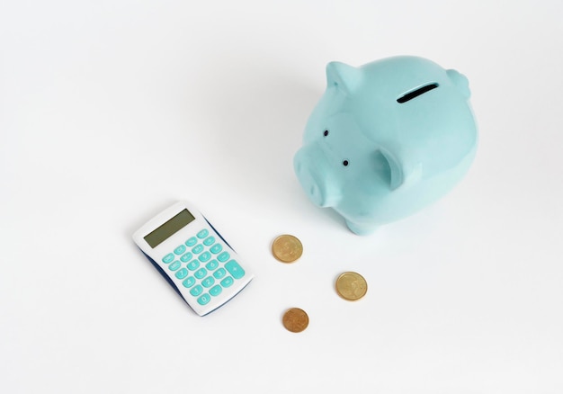 Illustration of counting money Blue piggy bank with calculator and coins on white background