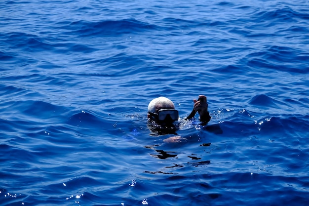 Foto illustrazione dell'ascesa del subacqueo alla superficie dell'acqua durante l'immersione.