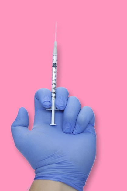 Photo illustration of a hand with syringe and blue glove