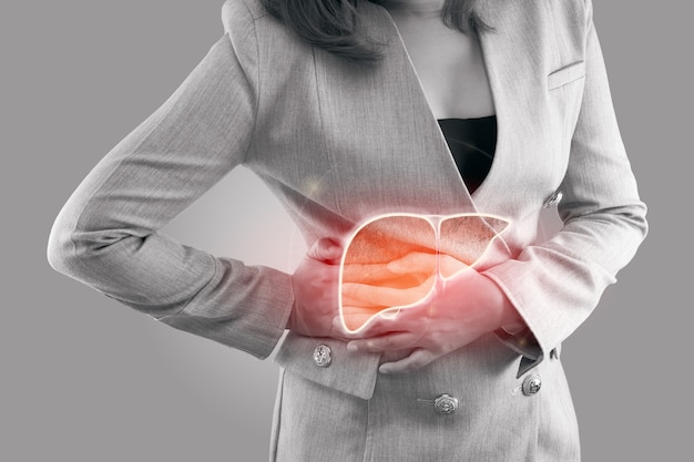 Photo illustration of liver on woman's body against gray background, hepatitis, concept with healthcare and medicine