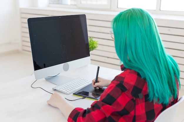Illustrator, creatief, webdesign concept - Vrouwelijke grafisch ontwerper met groen haar op het werk, rug
