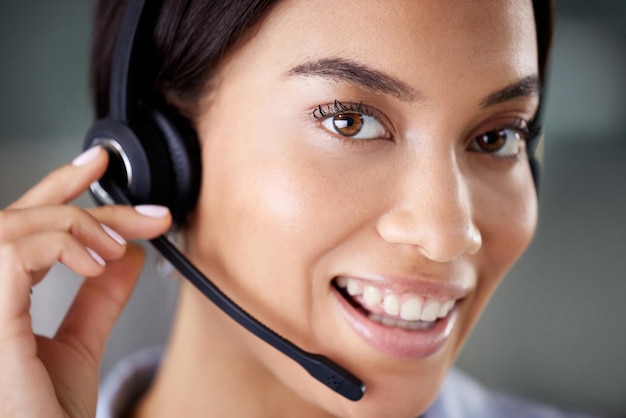 Im always ready to help. Shot of an attractive young call centre agent wearing a headset in the office during the day.