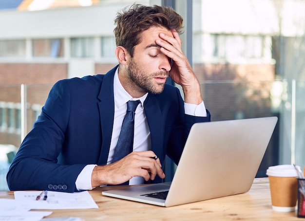 Im calling it a day Shot of a businessman looking exhausted while working on his laptop