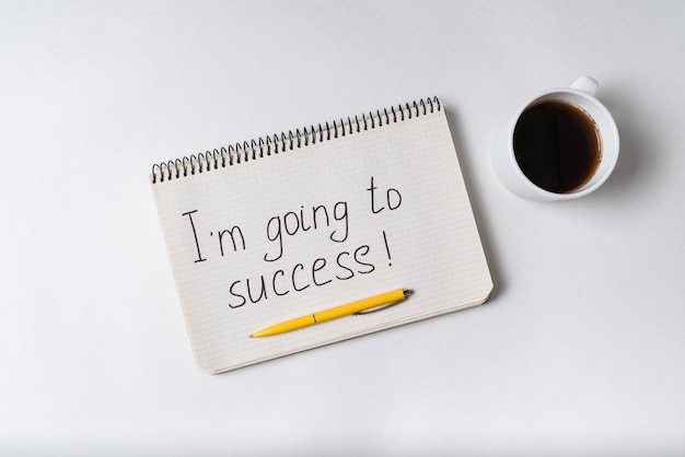 Im going to success inscription. Notebook, pen and cup of coffee.