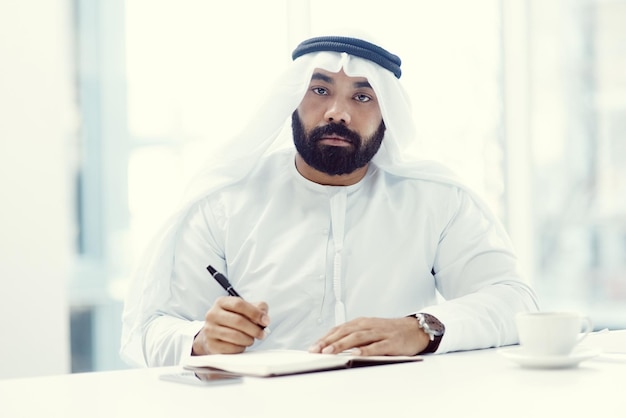 Im here to achieve my dreams Cropped portrait of a young businessman dressed in Islamic traditional clothing working in his office