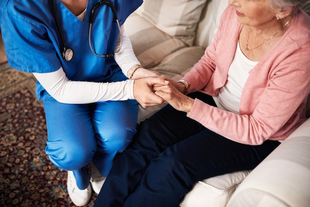 Photo im here if you need me cropped shot of a female nurse hold her senior patients hand