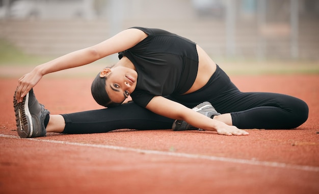 Im quite flexible Shot of an athletic young woman stretching while out on the track