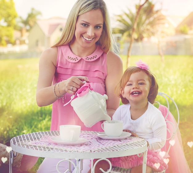 Im raising a little lady Portrait of a mother and her cute little girl having a tea party on the lawn outside