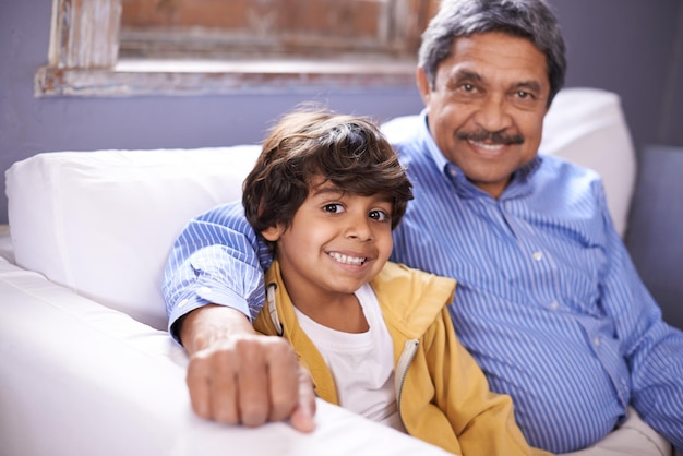 Im so proud of my grandson Portrait of a smiling grandfather and grandson sitting on a sofa at home
