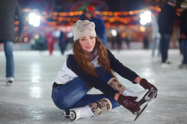 Photo im not sure how to stretch in skates portrait of an attractive young woman sitting on an ice rink stretching her arms