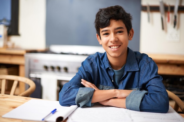 Photo im top of my class portrait of a young boy studying at a desk in a classroom