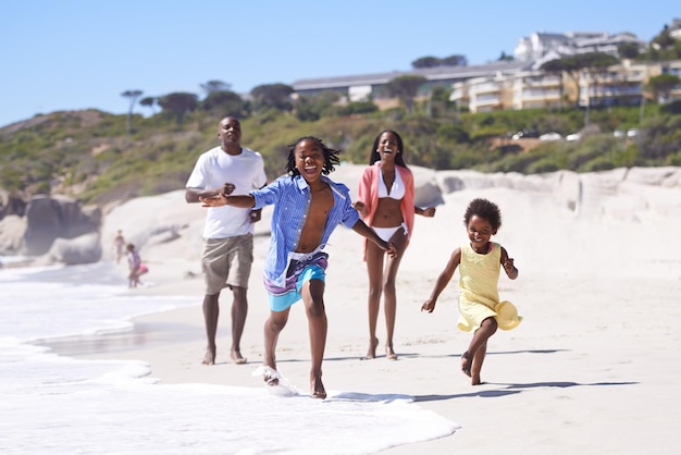 나는 경주에서 이기고 있다 해변을 따라 활기차게 달리는 행복한 젊은 아프리카 가족