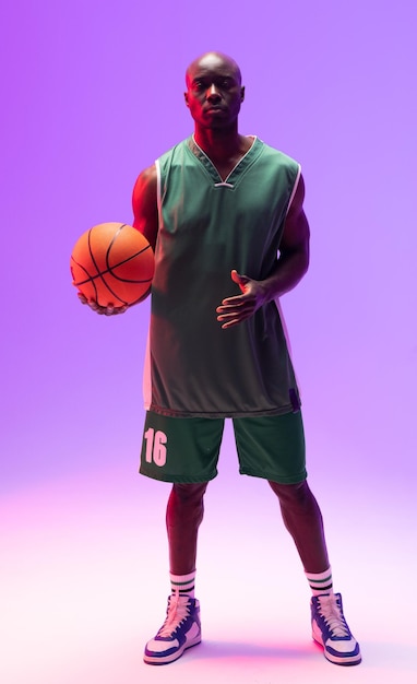 image of african american basketball player with basketball on neon purple background. sports and competition concept.