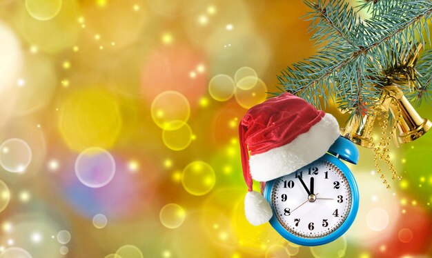 Image of alarm clock and red christmas hat as a christmas tree decoration