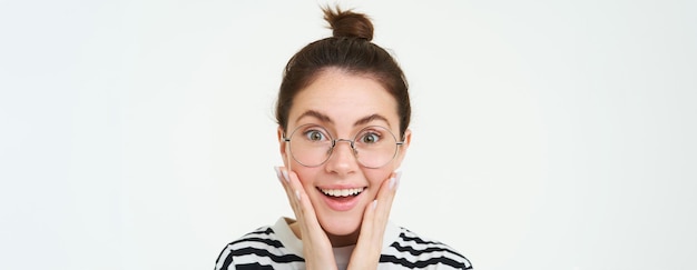 Photo image of amazed smiling young woman in eyewear wearing glasses looking impressed and excited