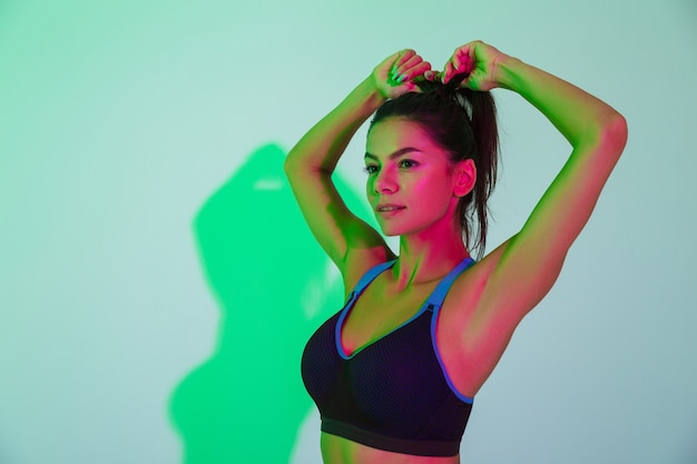 Image of amazing beautiful concentrated young sports woman posing isolated with led flash lights.