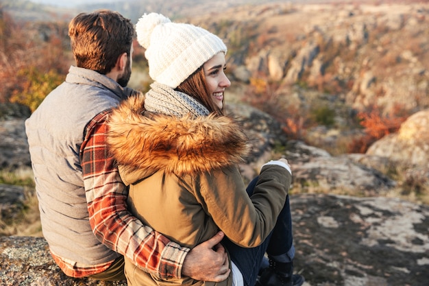 山を越えてキャンプする無料の代替休暇で外の驚くべき感情的な幸せな若い愛情のあるカップルの画像。