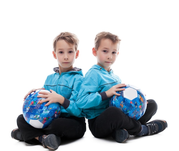 Image of amusing twin brothers posing with balls