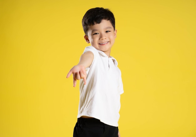 노란색 배경에 포즈를 취하는 아시아 소년의 사진 xA