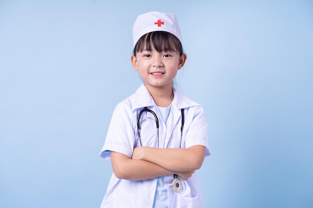 Image of Asian child wearing doctor uniform on blue background