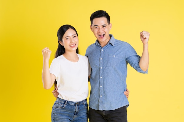 Image of asian couple posing on yellow background