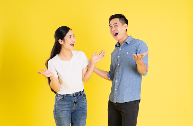 Image of asian couple posing on yellow background