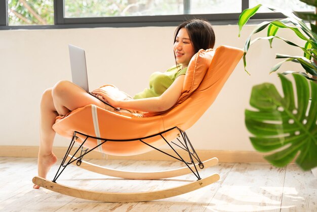 Photo image of asian girl relaxing on a chair at her house