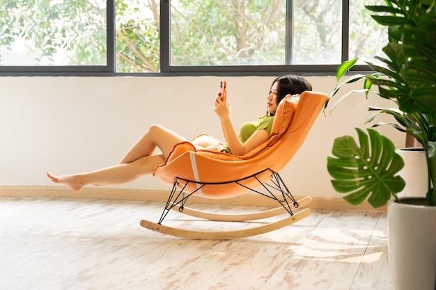 Photo image of asian girl relaxing on a chair at her house