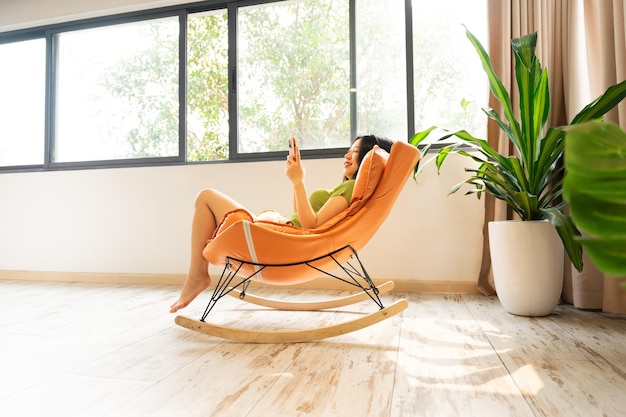 Image of asian girl relaxing on a chair at her house