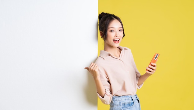 Image of asian girl standing and posing with billboard