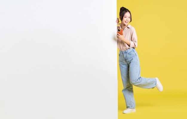 Image of Asian girl standing and posing with billboard